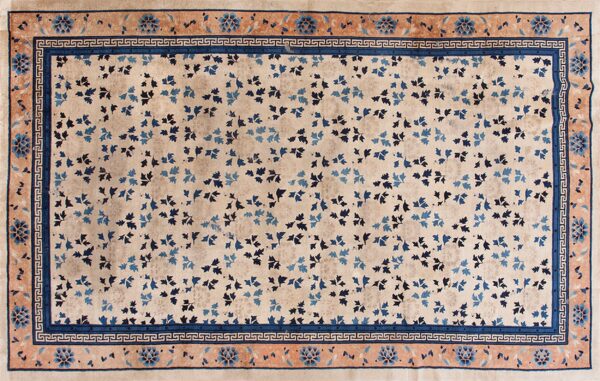 Beige rug featuring scattered blue leaves and a detailed rust and navy blue border.