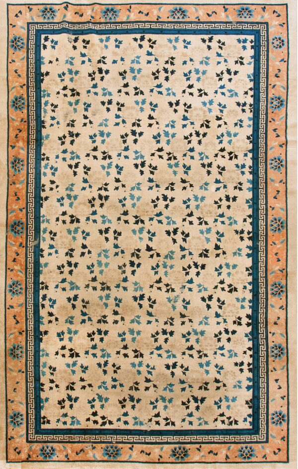 Beige rug with scattered blue and navy leaf patterns, framed by a wide peach floral border.