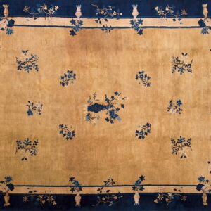 Ochre field rug with a dark blue border accented by floral vases and scattered blue and cream bouquets.
