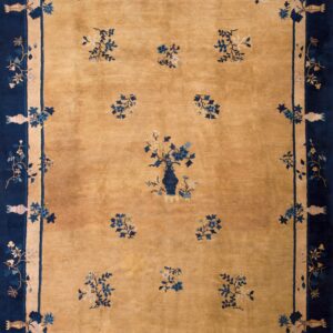 Gold rug with navy blue border and scattered floral motifs surrounding a central vase design.
