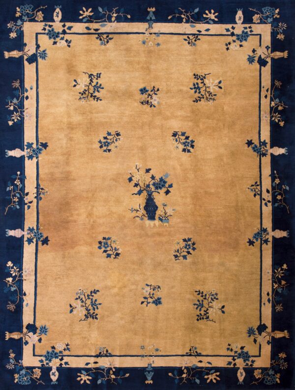 Gold rug with navy blue border and scattered floral motifs surrounding a central vase design.