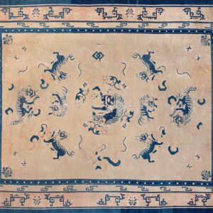 Rectangular rug with a tan field, blue stylized animal patterns, and intricate rose and indigo geometric borders.