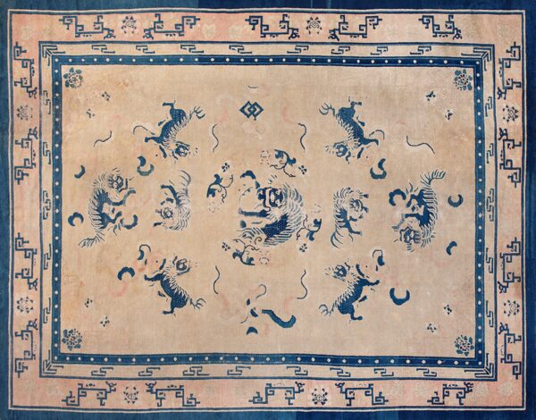 Rectangular rug with a tan field, blue stylized animal patterns, and intricate rose and indigo geometric borders.