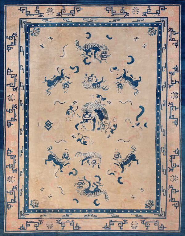 Beige field rug with dark blue stylized animals and a multi-layered border featuring geometric patterns.