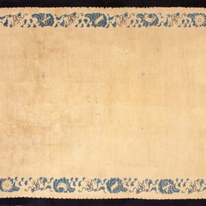 Light beige rug with an intricate blue patterned border and a solid dark navy frame.