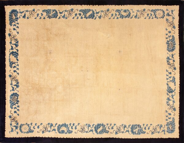 Light beige rug with an intricate blue patterned border and a solid dark navy frame.