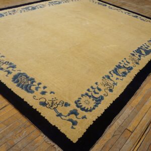 Pale yellow rug with a thick navy blue border featuring blue stylized floral designs on distressed wood planks.