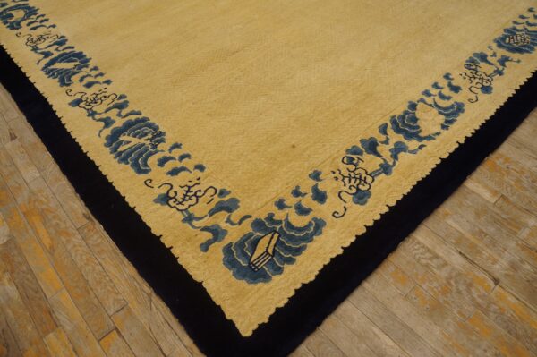 Yellow high-pile rug with a dense blue floral border detail and a dark edge, placed on wood flooring.