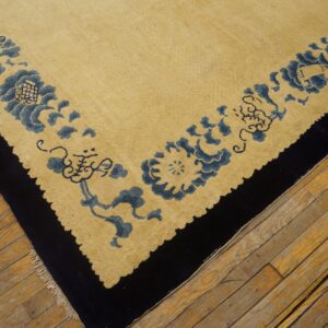 Yellow low-pile rug with a detailed blue floral border and dark outer edge on wooden flooring.