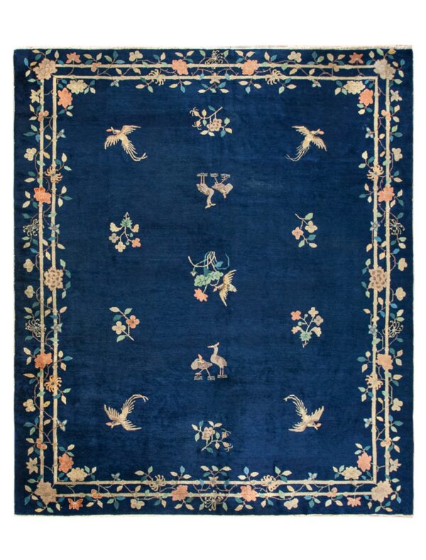 A rectangular blue rug with a dense pile, featuring scattered birds and floral designs within a bamboo-style border.