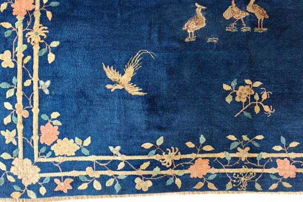 Deep blue high-pile rug with beige birds, peach flowers, and a bamboo trellis border design.