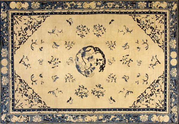 Beige rug featuring a detailed blue central medallion, corner spandrels, and scattered floral and butterfly patterns.