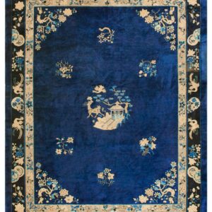 Deep blue rug with velvety texture, detailed beige and blue floral patterns, and a prominent black border.