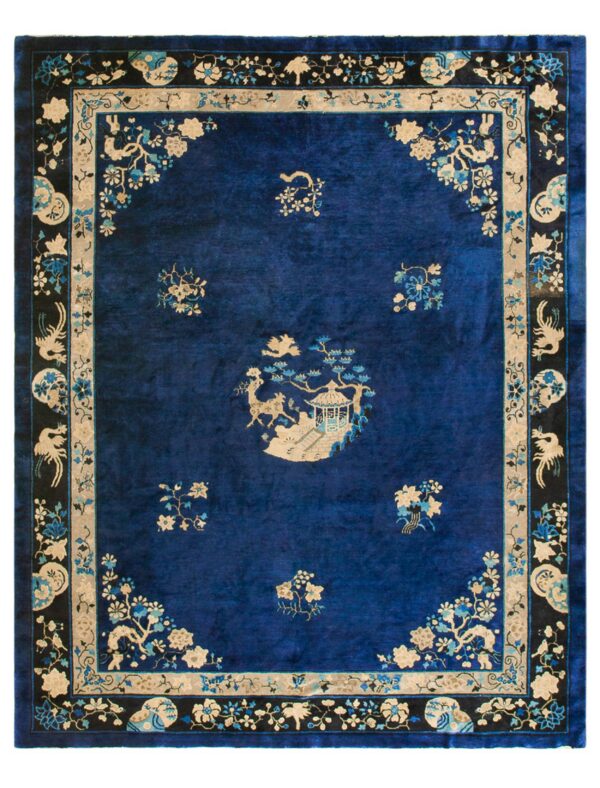 Deep blue rug with velvety texture, detailed beige and blue floral patterns, and a prominent black border.