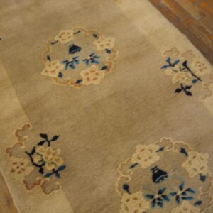 Muted beige rug runner with scattered blue and cream floral medallions visible on wood flooring.