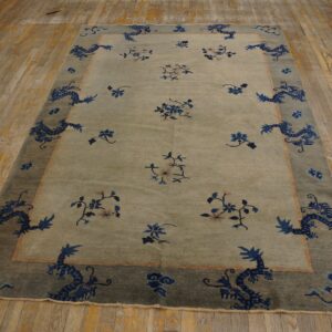 Light gray-green rug with scattered blue florals and a dark border featuring blue dragons rests on wood floorboards.