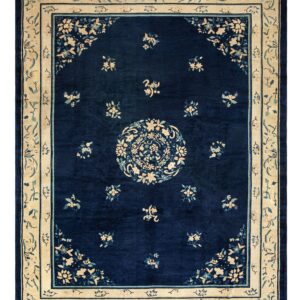 Dark blue rug featuring an intricate cream and teal floral pattern, central medallion, and wide border.