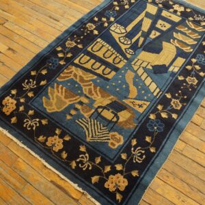 Deep blue and gold abstract patterned rug with a dark floral border covers light wood floors.