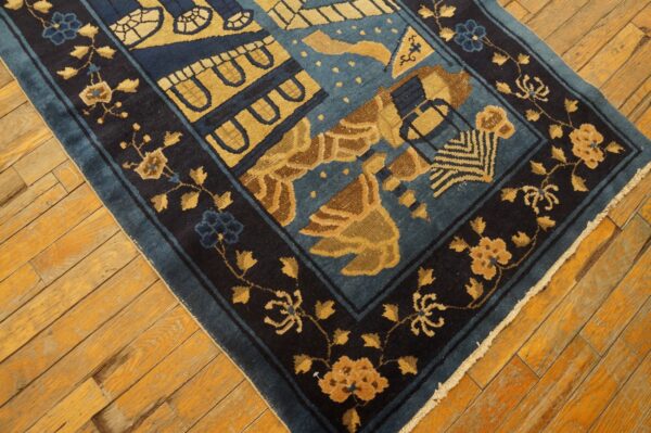 A teal rug with stylized gold and dark blue patterns rests on distressed warm-toned wood planks.