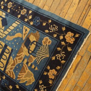 Blue and gold patterned rug with a deep navy floral border shown on rustic wood planks.