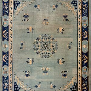 Light blue rug with navy and tan accents featuring a central medallion and scattered traditional symbols.