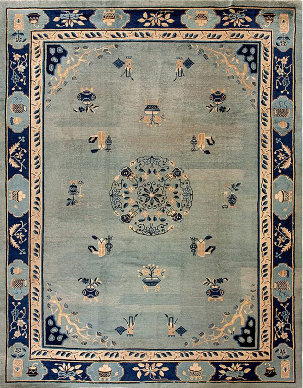 Light blue rug with navy and tan accents featuring a central medallion and scattered traditional symbols.