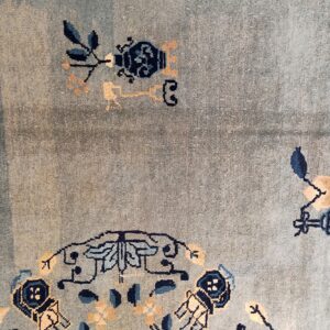 Light blue textured rug featuring stylized designs in navy, light blue, and beige colors.