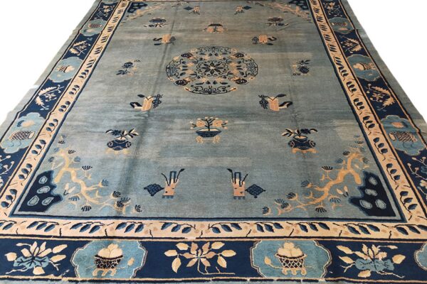 Light blue rug with an oriental central medallion and scattered motifs in dark navy and tan.