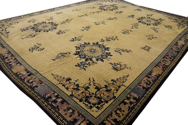 Angled view of a pale gold rug with stylized blue and brown floral patterns and complex geometric borders.