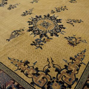 Gold rug with scattered blue and black floral patterns and complex geometric borders.