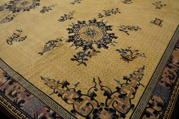 Gold rug with scattered blue and black floral patterns and complex geometric borders.