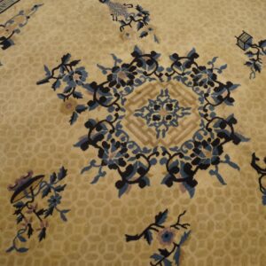 Gold rug with a subtle honeycomb pattern features a large central floral medallion in blue and black.
