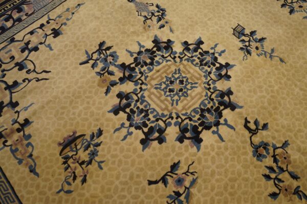 Gold rug with a subtle honeycomb pattern features a large central floral medallion in blue and black.