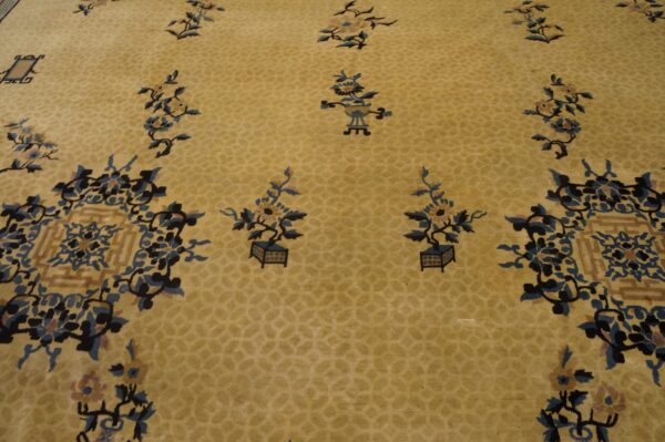Yellow low-pile rug featuring scattered potted plants and elaborate blue and navy floral medallions.