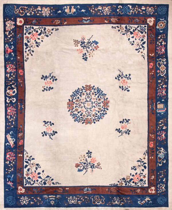 Pale beige rug with a central floral medallion and border in deep blue, rust, and pink.