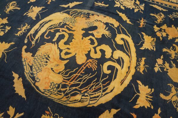 Low-pile dark blue rug featuring a central ochre dragon and scattered floral pattern.