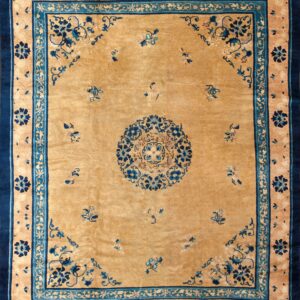 A gold field rug featuring a navy and turquoise medallion with matching intricate floral borders.