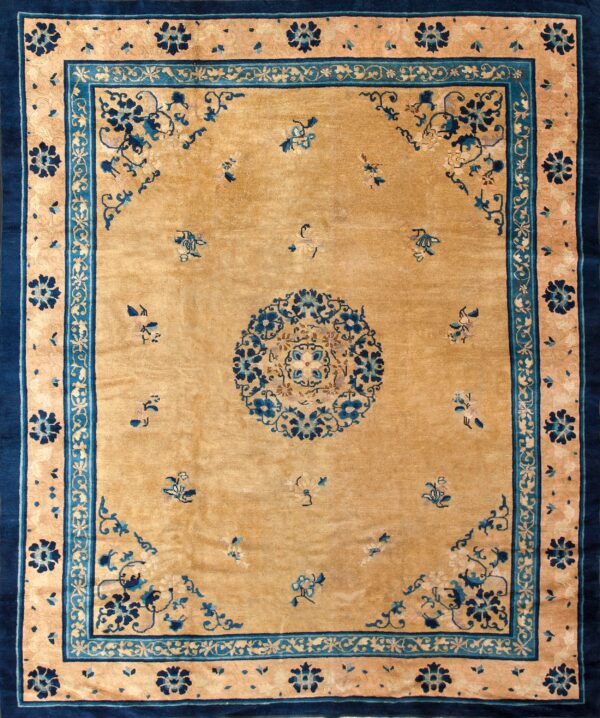 A gold field rug featuring a navy and turquoise medallion with matching intricate floral borders.