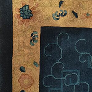 Deep blue rug field with teal scrolls meets a golden border featuring scattered floral and leaf designs.