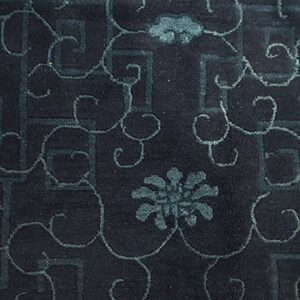 Dark indigo rug featuring low-contrast teal geometric fretwork and elaborate scrolling botanical motifs.