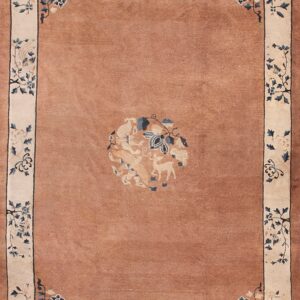 Low pile rug with a dusty rose field, a central deer medallion, and a cream border with blue florals.