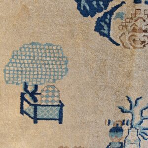 Beige rug detail with stylized deep and light blue floral and lattice geometric patterns.