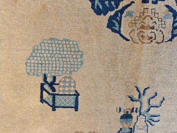 Beige rug detail with stylized deep and light blue floral and lattice geometric patterns.