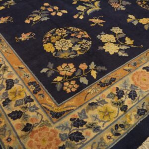 Navy high-pile rug featuring a scattered floral pattern and wide border on wooden floorboards.