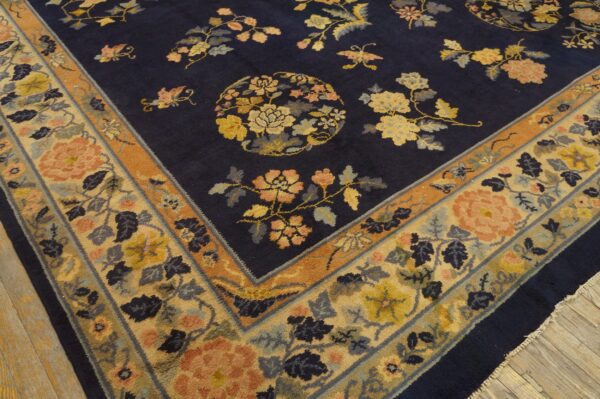 Navy high-pile rug featuring a scattered floral pattern and wide border on wooden floorboards.