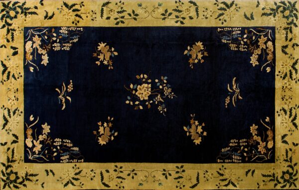 High-contrast rug with a dark navy field and gold floral sprays, framed by a broad yellow-green border.