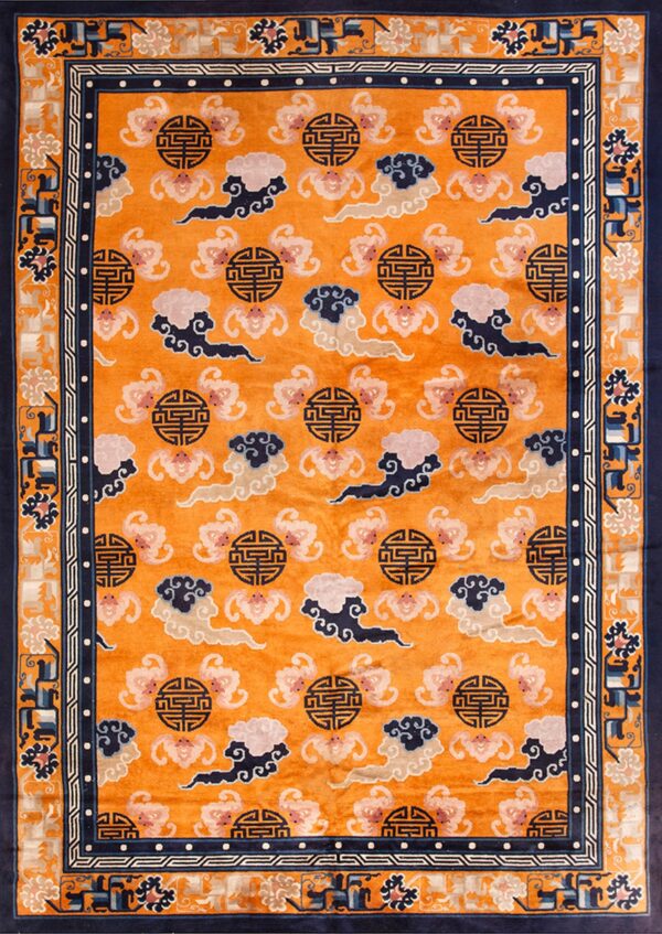 Orange field rug featuring stylized pink, navy, and cream cloud patterns and dark geometric medallions inside a navy border.