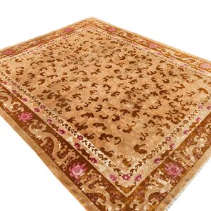 Tan and brown rug with stylized cloud motifs and wide decorative borders featuring pink floral accents.
