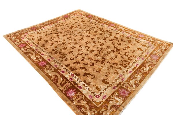 Tan and brown rug with stylized cloud motifs and wide decorative borders featuring pink floral accents.