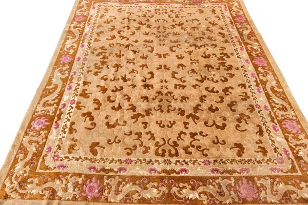 Beige rug featuring embossed brown cloud patterns and a detailed border accented with pink floral motifs.